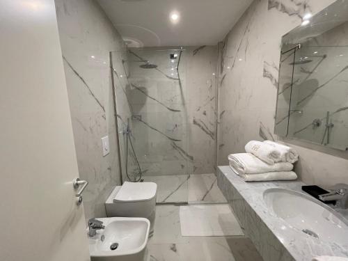 a bathroom with a toilet and a sink and a shower at Volmar Hotel in Durrës
