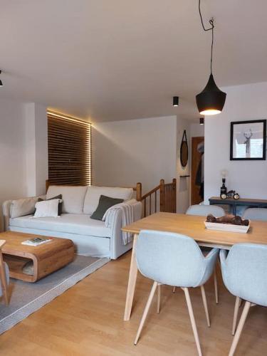 a living room with a couch and a table at Acogedor dúplex en el Valle de Aran in Caneján