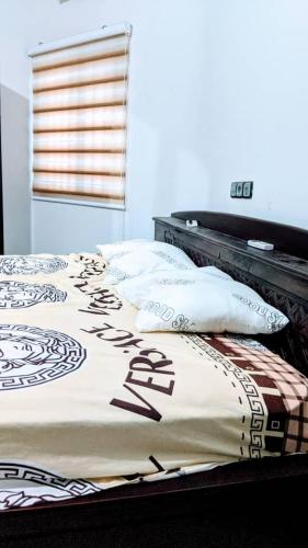 a bed with a blanket and pillows on it at Appart de deux chambres salon scindé en cours unique à Louer in Lomé