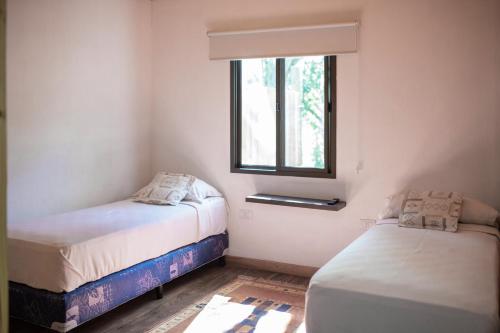 a small room with two beds and a window at Complejo Paranay in Puerto Paranay