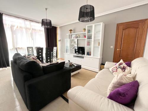 a living room with two chairs and a black and white couch at Apartamentos Gran Via in Salamanca