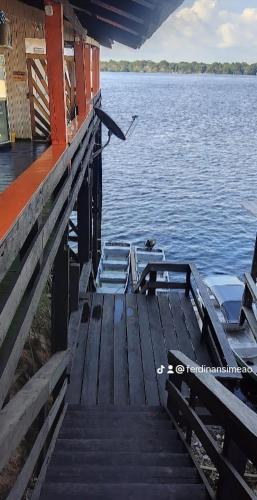 a dock with chairs sitting on top of the water at EL DORADO POUSADA in Barcelos
