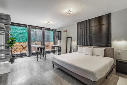 1 dormitorio con cama, mesa y balcón en Hotel Singular Goldsmith, en Ciudad de México