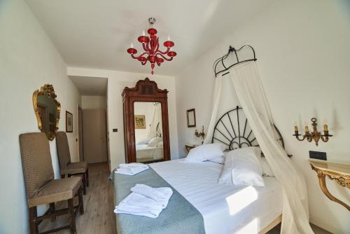 a bedroom with a bed and a chair and a chandelier at B&B La Loggia Del Castello in Trento
