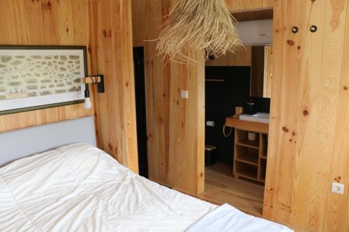 a bedroom with a bed and a bathroom with a sink at CASA DO ARCO - BARCELOS in Barcelos