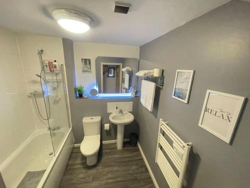 a bathroom with a toilet and a sink and a tub at Cityfront Cosy Apt Near City Centre & Etihad Stadium, Free Parking in Manchester