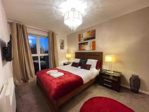 a bedroom with a large bed with a red blanket at Cityfront Cosy Apt Near City Centre & Etihad Stadium, Free Parking in Manchester