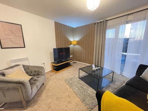 a living room with a couch and a tv at Cityfront Cosy Apt Near City Centre & Etihad Stadium, Free Parking in Manchester