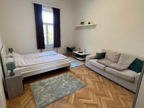 a living room with a bed and a couch at Tamás Apartman in Székesfehérvár