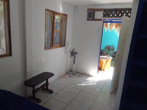 um quarto com uma cadeira e uma porta com uma janela em Mar Caribe PV em Puerto Viejo