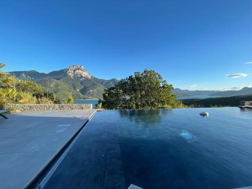 a swimming pool with a view of the water at Les Restanques du lac in La Chapelle