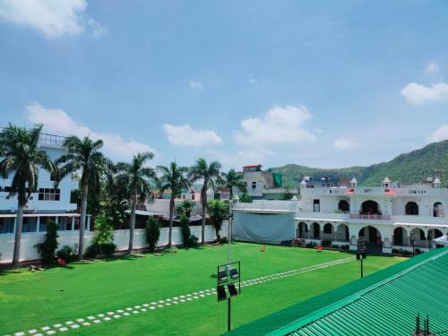 ein großes Gebäude mit einem grünen Feld davor in der Unterkunft Hill Top Residency in Sawāi Mādhopur