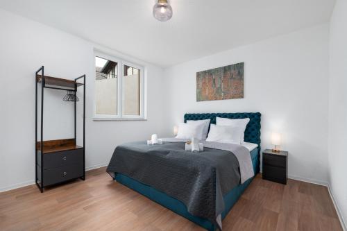 um quarto com uma cama azul e um espelho em Modernes Apartment, Altstadt, Parkplatz, NETFLIX em Quedlinburg