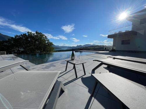 a glass bottle of wine sitting on a patio with water at Les Restanques du lac in La Chapelle