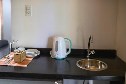 a kitchen counter with a tea kettle and a sink at Complejo Paranay in Puerto Paranay