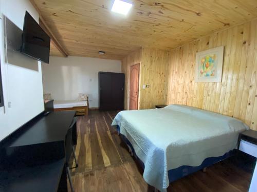 a bedroom with a bed in a wooden room at Complejo Paranay in Puerto Paranay