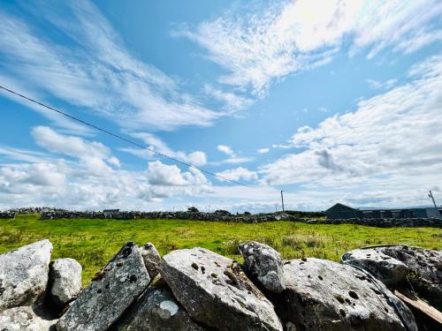a pile of rocks in a field with a sky at Apartment in Connemara in Galway