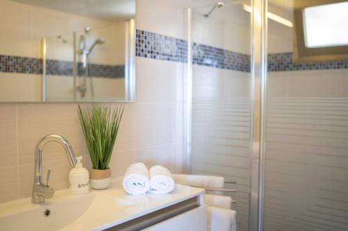 a bathroom with a shower and a sink with towels at Hakochav in Eilat