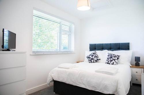 a bedroom with a bed with a window and a tv at Newly Renovated 2 Bed house in Penryn