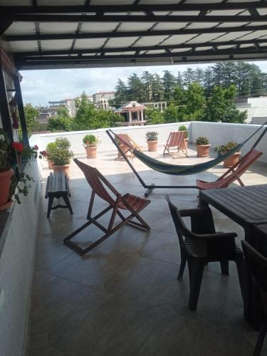 a patio with chairs and a hammock on a roof at White Hotel Guesthouse in Zugdidi