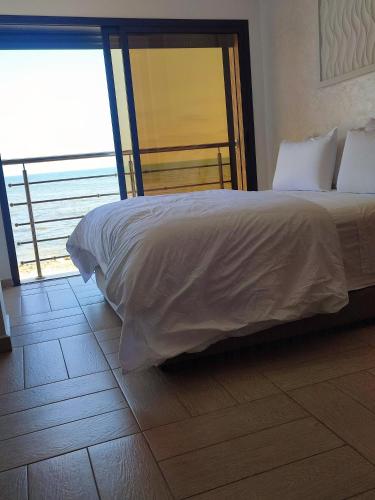 - une chambre avec un lit et une vue sur l'océan dans l'établissement clapotis, à El Jadida