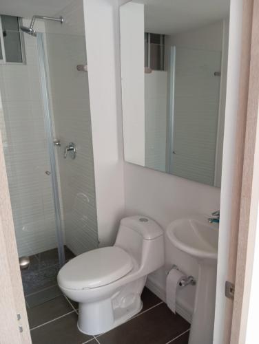 a white bathroom with a toilet and a sink at Apartamento en Peña Azul "La Aldea" Ricaurte, Cundinamarca in Ricaurte