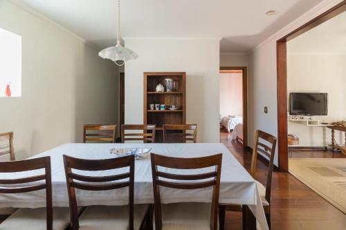 comedor y sala de estar con mesa y sillas en Casa espaçosa c/lareira em Campos do Jordão RAS175, en Campos do Jordão