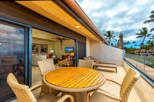 a wooden table and chairs on a balcony at MAKENA SURF #B304 condo in Wailea