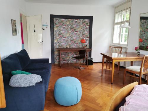 a living room with a blue couch and a table at Gundis Gästezimmer in Bamberg