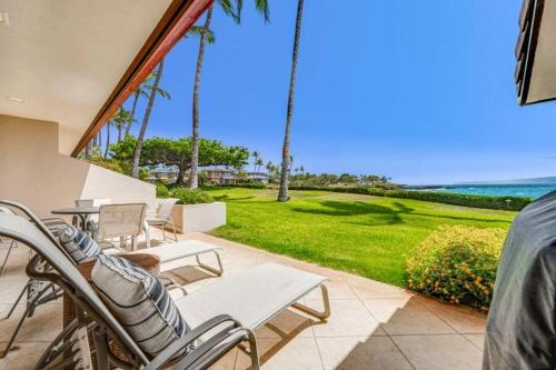 a patio with chairs and a view of the ocean at MAKENA SURF #F-102 condo in Wailea