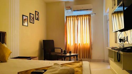 a room with a bed and a chair and a window at JACK'S DEN residency in Puducherry