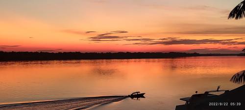a sunset over a body of water with a dock at EL DORADO POUSADA in Barcelos