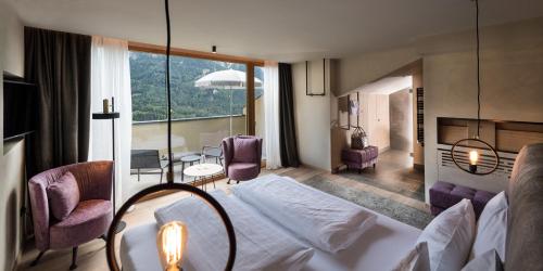 een hotelkamer met een bed en een tafel en stoelen bij Hotel Valentinerhof in Siusi