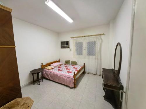 ein Schlafzimmer mit einem Bett und einem Tisch in einem Zimmer in der Unterkunft Rental home ismailia in Ismailia