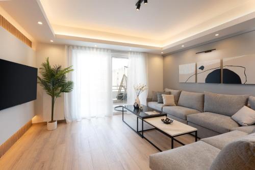 - un salon avec un canapé et une table dans l'établissement Luxury 4 Bedrooms Apartment Near Flisvos Marina, au Pirée