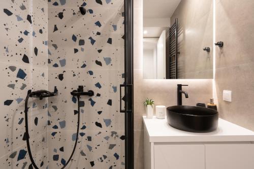 La salle de bains est pourvue d'une douche et d'un lavabo noir. dans l'établissement Luxury 4 Bedrooms Apartment Near Flisvos Marina, au Pirée