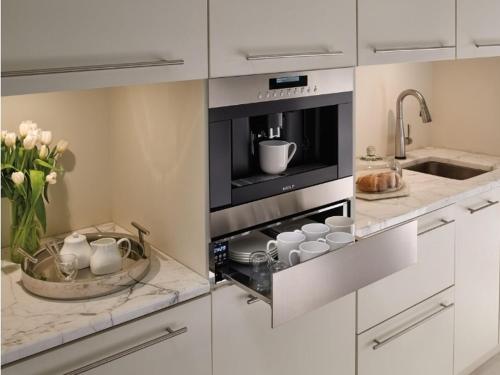 a kitchen with a microwave with cups and a sink at West Edmon. Mall = Room in Edmonton