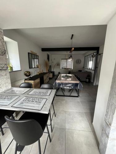 een woonkamer met een tafel en stoelen bij Maison villageoise in Anhée