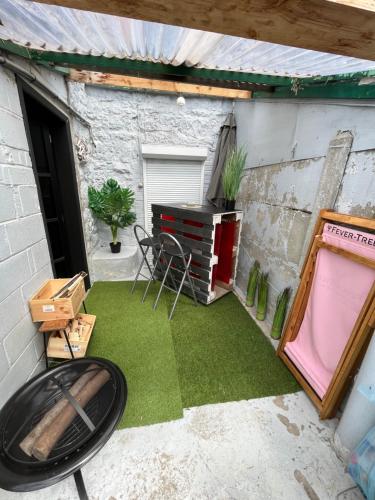 a small patio with green grass and a table at Maison villageoise in Anhée