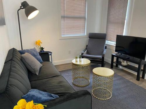 a living room with a couch and a television at Contemporary 1-Bedroom Private Bungalow Walk to Armature & Riverwalk in Tampa