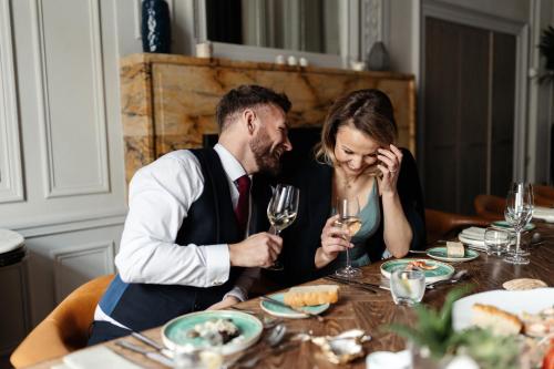 a man and a woman sitting at a table with wine glasses at Kimpton Blythswood Square Hotel & Spa by IHG in Glasgow