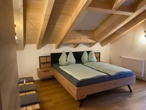 Schlafzimmer mit einem großen Bett und Holzdecken in der Unterkunft Ferienwohnung Ferchensee in Mittenwald