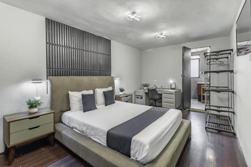 1 dormitorio con cama, escritorio y escalera en Hotel Singular Goldsmith, en Ciudad de México