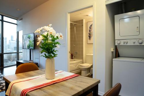 a dining room table with a vase of flowers on it at Lovely 1 bed in Central Toronto in Toronto