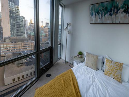 a bedroom with a bed and a large window at Lovely 1 bed in Central Toronto in Toronto