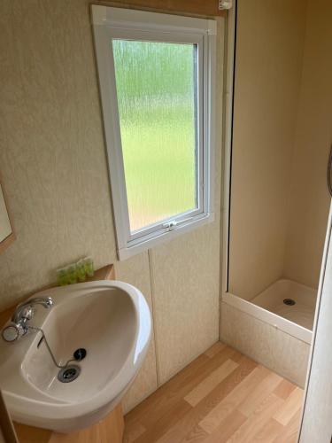 uma casa de banho com um lavatório e uma janela em Le Cottage em Fraize