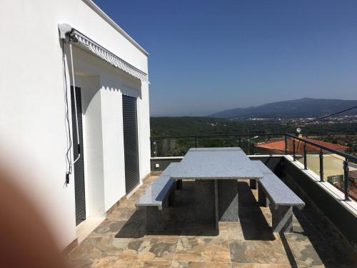 a picnic table on the balcony of a white building at Villa Santo Antonio in Serra do Mouro