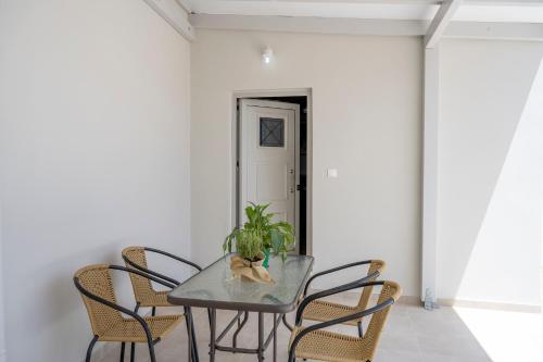 a dining room table with chairs and a plant on it at Klelia's Apartments in Palekastron