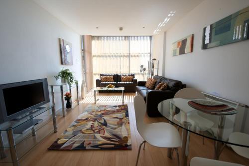 uma sala de estar com um sofá e uma mesa de vidro em Stay Deansgate Apartments for 14 nights plus em Manchester