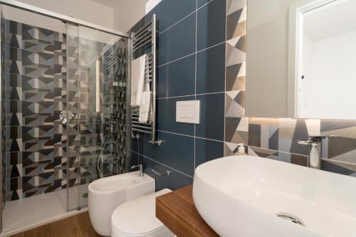 łazienka z białą umywalką i toaletą w obiekcie Due Golfi Apartment w mieście SantʼAgata sui Due Golfi